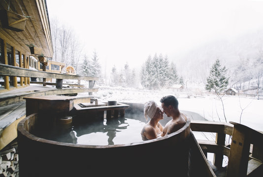 Couple sitting in plunge tub in winter