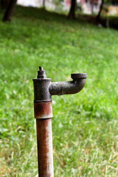 Old water pipes outside / Faucet with nature background / A old rusty water tap in garden.