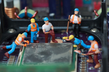 Selective focus of miniature engineer and worker fixed and repair CPU processor,  mainboard computer and use for business background.