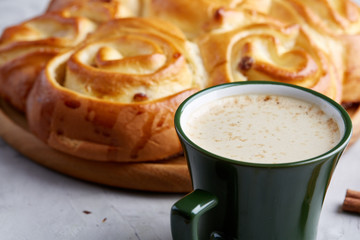 Homemade rose bread, cup of coffee, anise and cinnamon on white textured background, close-up, shallow depth of field