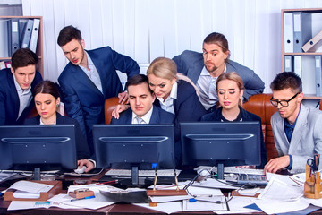 Business people office life of team people working with papers sitting table. Cabinets with folders and jalousie background. Schemas and diagrams on computer monitor. Modern methods of doing business.