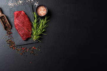 Raw beef steak on dark concrete table. Top view