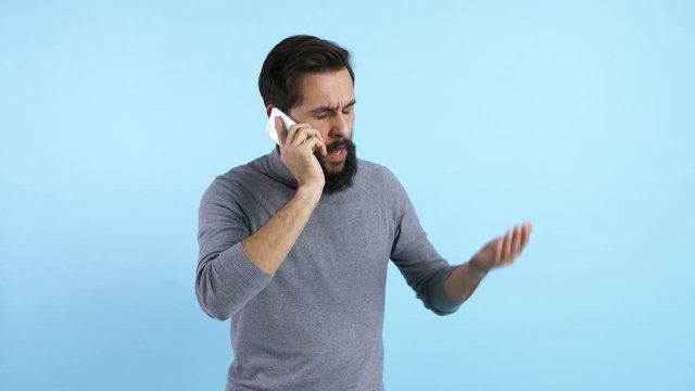Displeased man talking by mobile phone 
