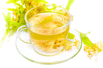 Tea from Linden flowers in glass cup with flower clusters of lime about a cup isolated on white background
