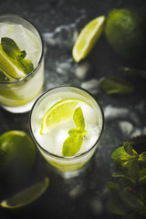 Mojito cocktail with lime and mint in glass on a stone table.