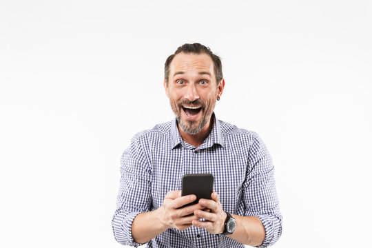Surprised emotional adult man using mobile phone.