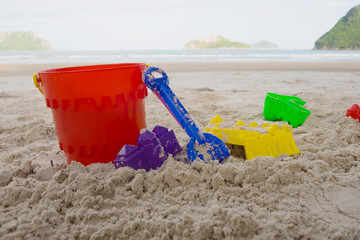 beach toys  buckets, spade and shovel on sand, beach background