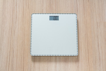 digital weight scale on wooden floor, shown zero kilogram