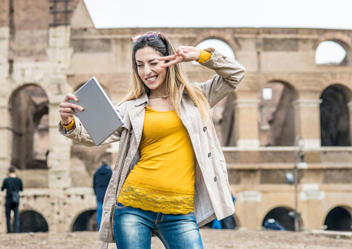 Tourist with tablet doing self portrait at colosseum monument in Rome