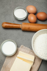 Bake cook with kitchen tools and ingredients: flour, eggs, butter, sugar.