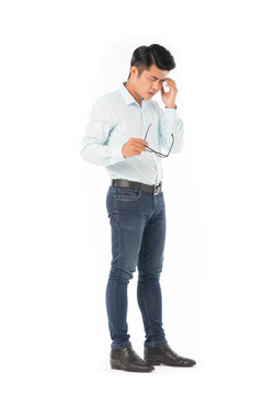 Full length portrait of young Asian man suffering from headache isolated on white