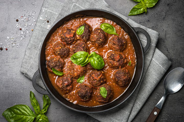 Meatballs in tomato sauce on a black background. 