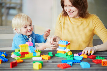 Mother playing colorful construction blocks with her son