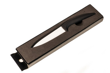 Ceramic knife with black handle in box isolated on black backgro