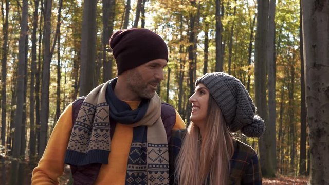 Affectionate couple talking and walking in forest