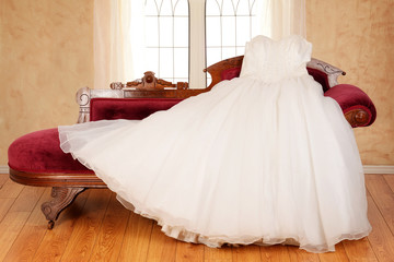 tulle wedding dress laying on chaise lounge