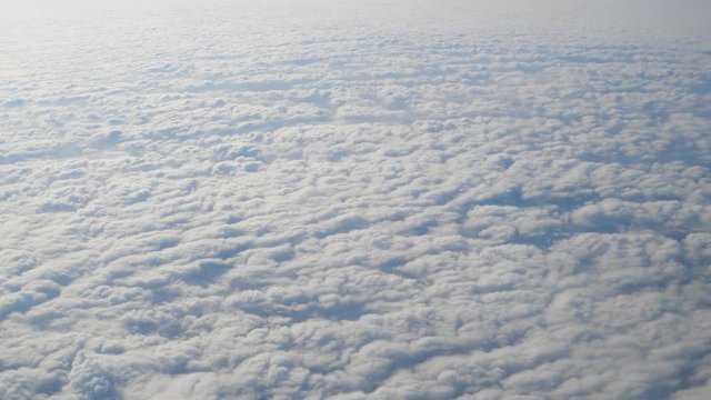Flight above clouds natural view from side window of airplane