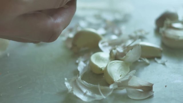 man is cleaning garlic close-up cloves. Vegetarians indoors garlic food in the kitchen lifestyle
