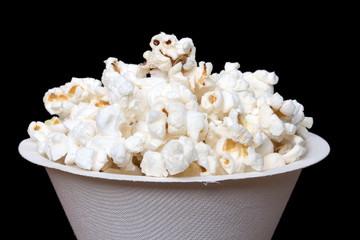 Popcorn in white bucket on black background, macro view.