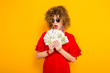 Attractive woman with short curly hair with cash - obrazy, fototapety, plakaty