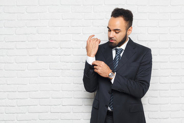 Young fashionable men in a suit against brick wall