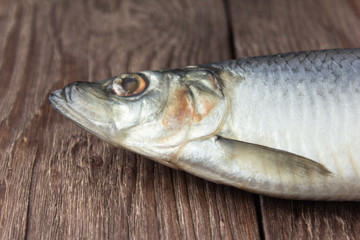 close up of tasty salted herring on wooden background, fish head close up