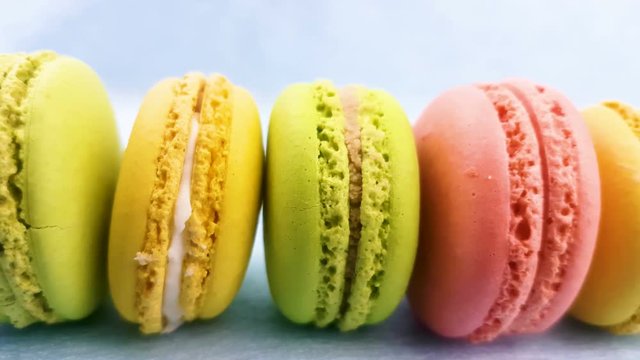 Sweet color macaroons or macaron on pastel pink background. Close up slide.