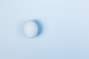 Blue egg on blue background. Top view, copy space. Food background