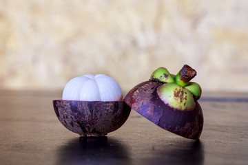 Mangosteen with cross section showing the thick purple skin and white flesh