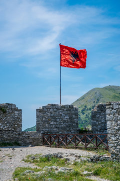 Albanian red flag with a black double-headed eagle towers above the fortress of Rozafa.