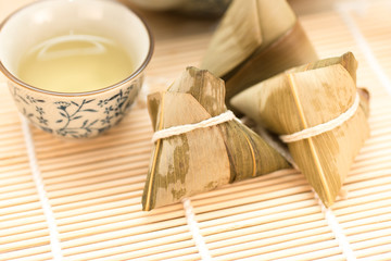 Zongzi or Traditional Chinese Sticky Rice Dumplings on Wooden Placemat