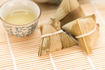 Fototapeta na wymiar Zongzi or Traditional Chinese Sticky Rice Dumplings on Wooden Placemat
