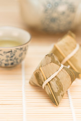 Zongzi or Traditional Chinese Sticky Rice Dumplings on Wooden Placemat