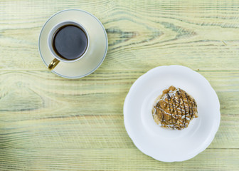 Coffee in a retro cup and cake on a wooden background.