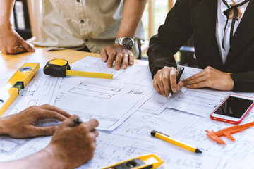 Team engineer asian colleagues discussing and checks construction blueprints on new project at desk...