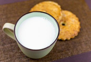 A cup of milk and cookies.