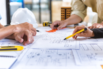 Image of team engineer checks construction blueprints on new project with engineering tools at desk...