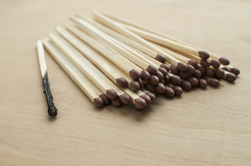 Burnt and whole head long wooden safety matchsticks on wooden background