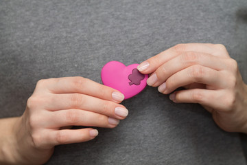 St Valentine's symbol: woman's hands holding a little heart next to the chest where a real heart is situated
