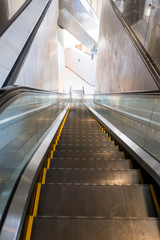 Escalators running down in a white building
