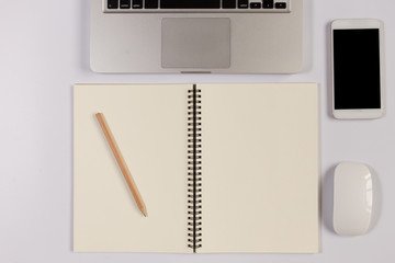 White Office desk table with laptop,smartphone and coffee cup and accessories. Business desk with a keyboard, mouse and pen on white table. Top view of workplace