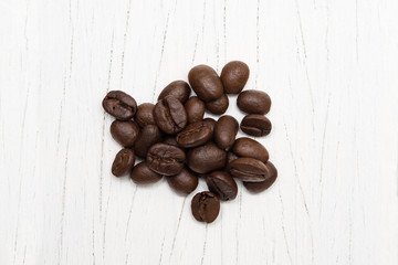 Roasted of coffee beans on white wood background.