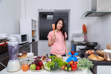 holding wooden spatula turner in kitchen room