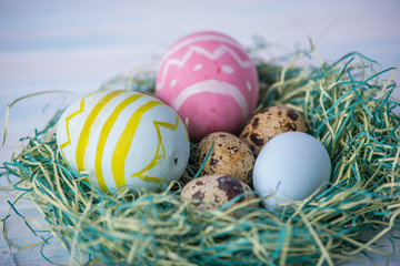 Colorful bright hand painted Easter eggs in a nest. Holiday spring card