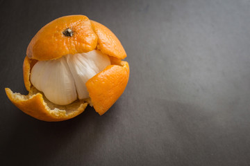 Garlic in a tangerine skin. - obrazy, fototapety, plakaty