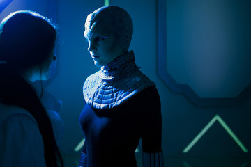 Woman and an alien look at each other. Contact with other civilizations