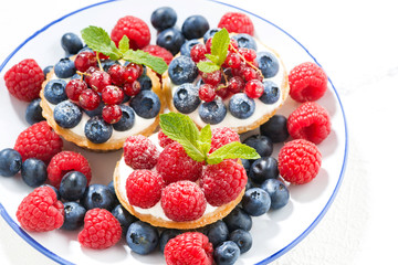mini cakes with sweet cream and berries on plate