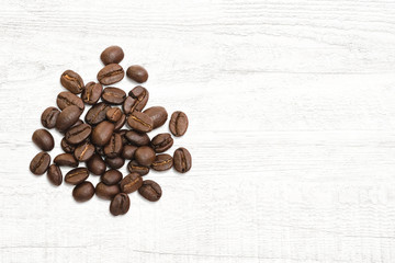 Roasted of coffee beans on white wood background.