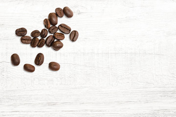Roasted of coffee beans on white wood background.