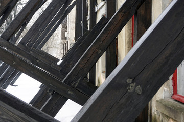 Wooden boards supporting old building from ruining. Concept of long-term support relationship closeup